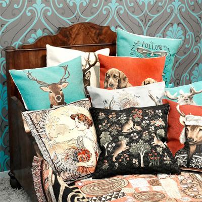 ausgefallene Kissen mit bunten Motiven und Bildernauf Bett
