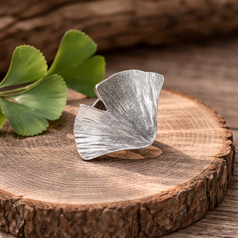 Silberring Ginkoblatt auf einer Holzscheibe